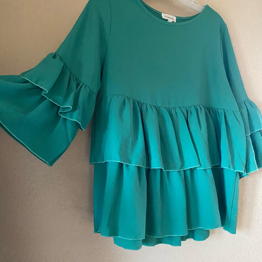 Flattering teal top with flowy detail!